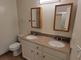 Bathroom has 2 sinks and 2 showers